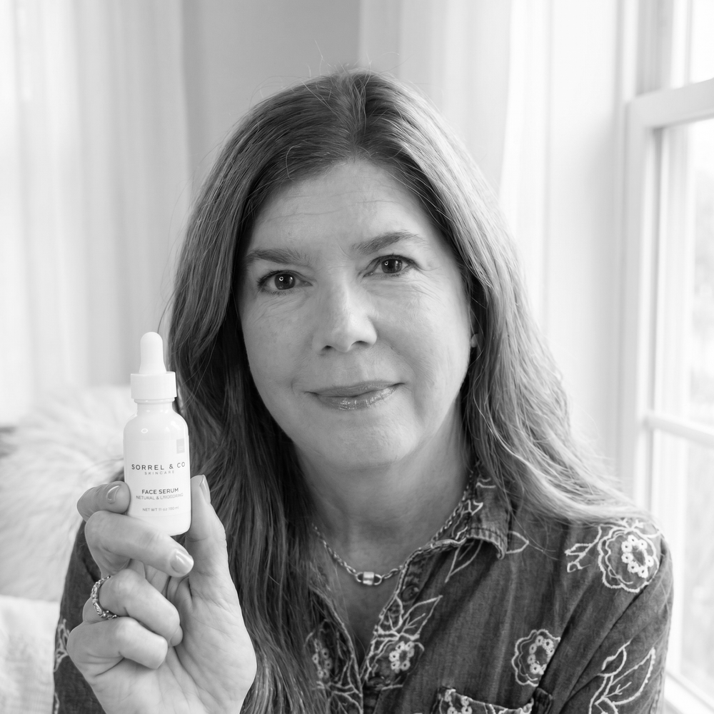 Kris, co-founder of Sorrel & Co, holding the Face Serum — black and white portrait